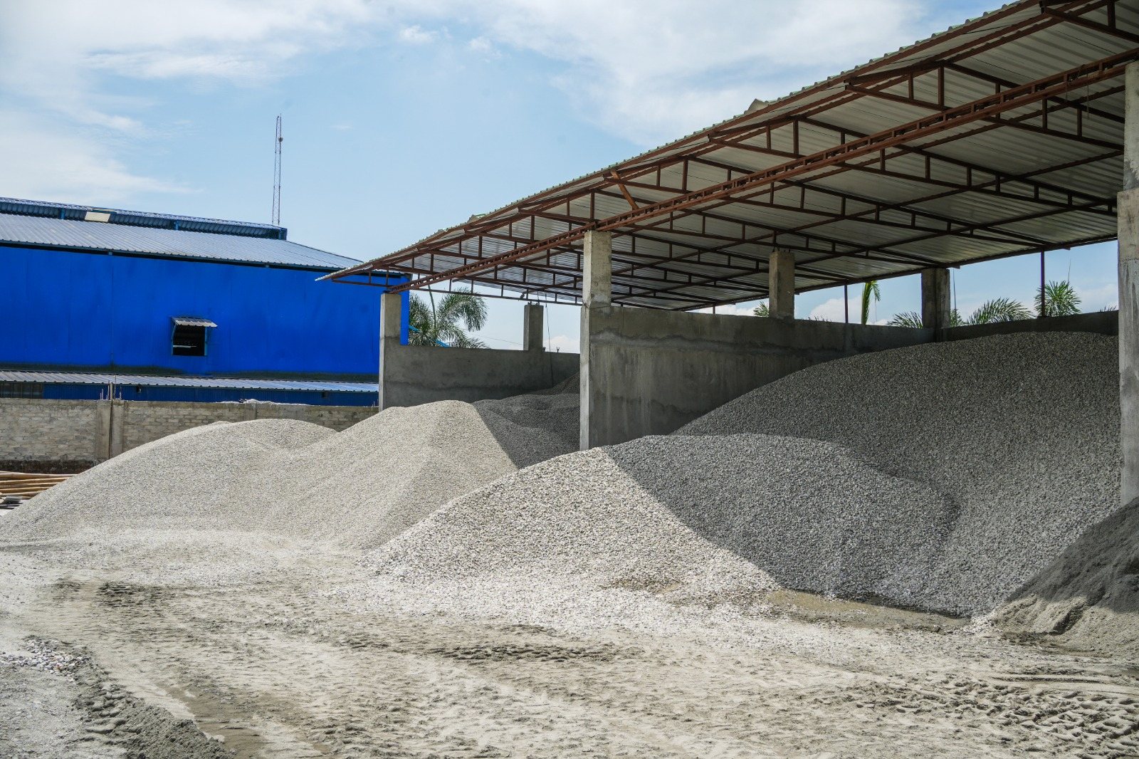 Graded stone aggregate stockpiles under cover at the plant